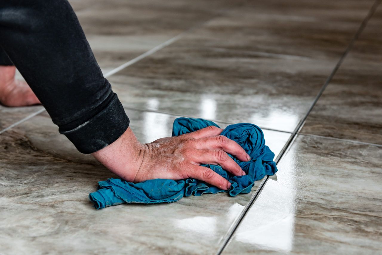 Worker washing tiles after jointing.