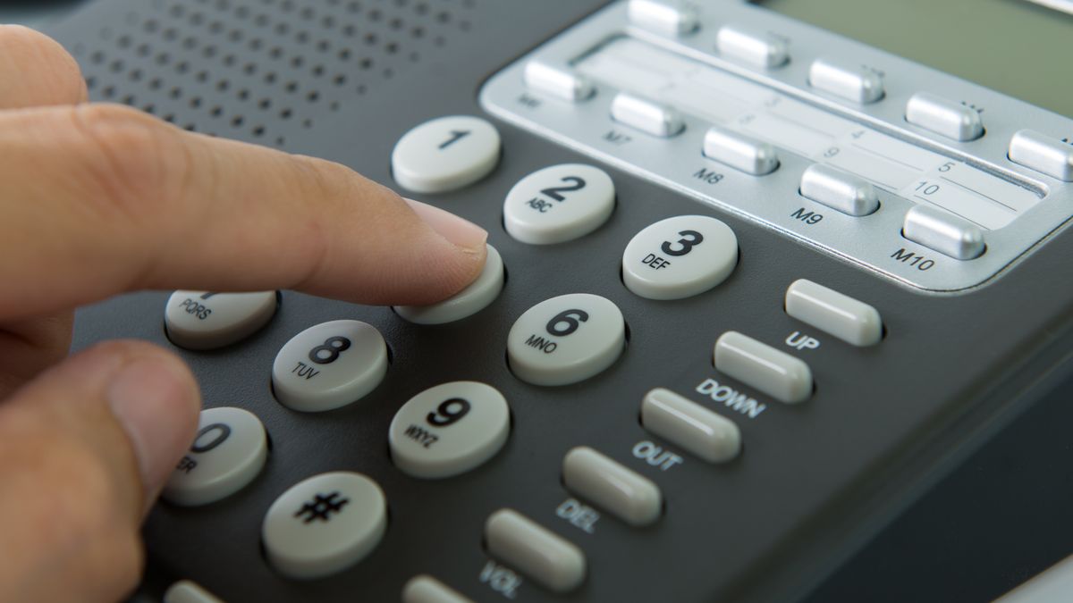 Close up of man dialing on a landline telephone
