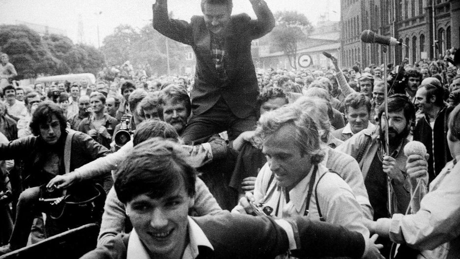 Sierpień '80. Stocznia Gdańska. Robotnicy niosą na rękach nieznanego mężczyznę w średnim wieku.