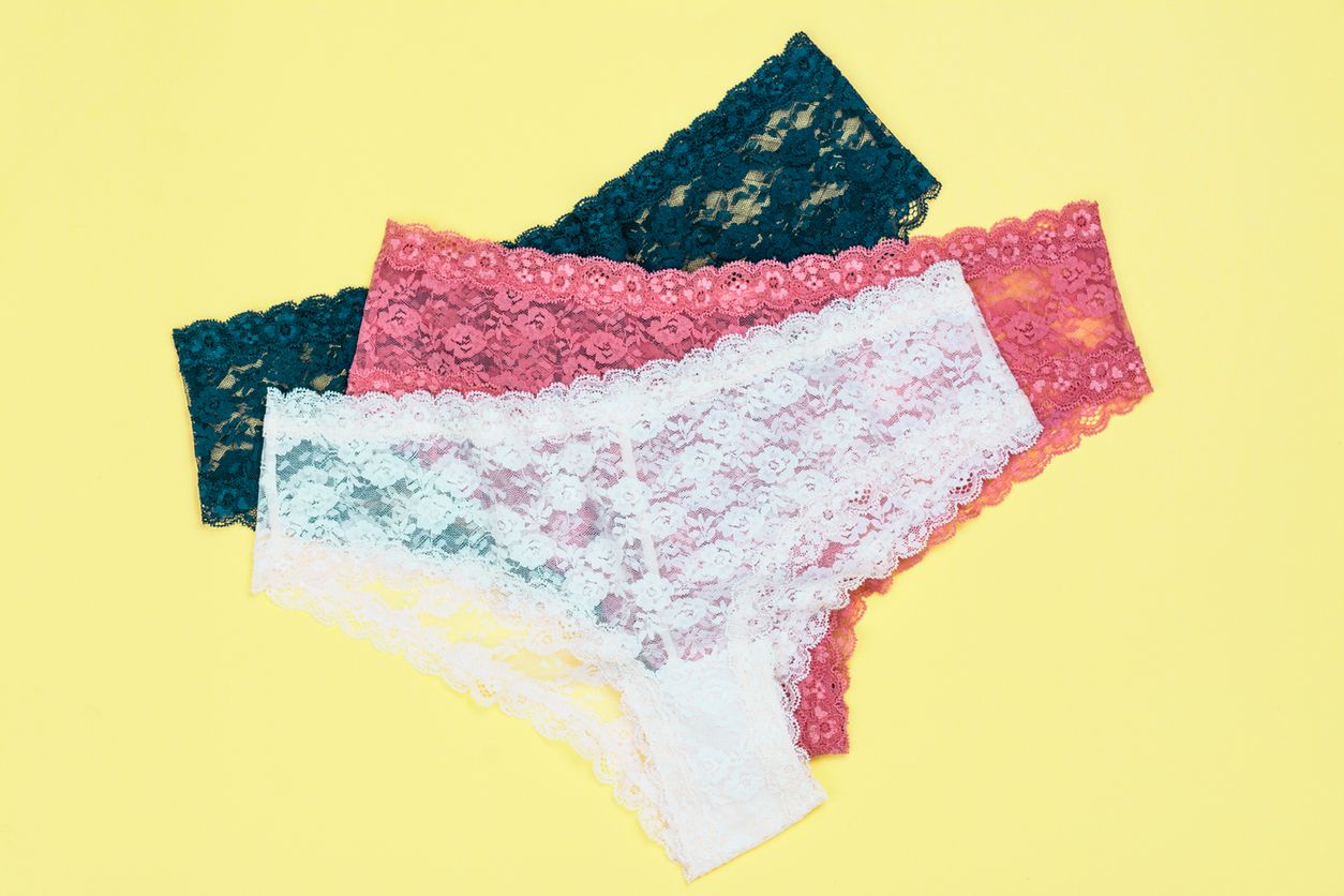 Set of beautiful lace panties on yellow background. Copy space 