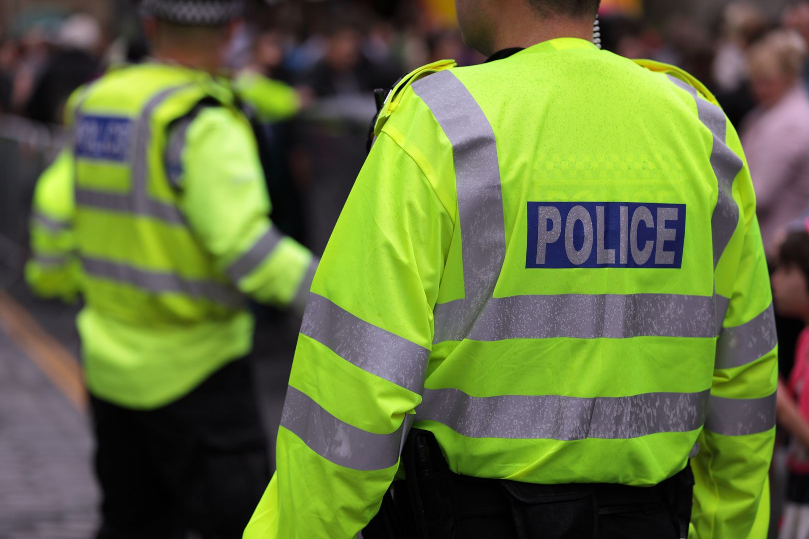 Police in hi-visibility jackets policing crowd control at a UK event