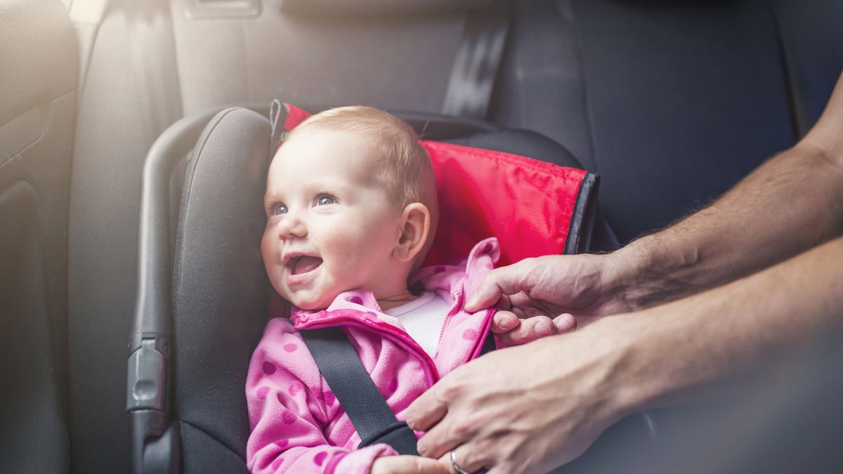 Little baby girl in a car in a child seat