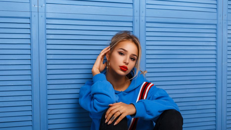 Bluza z kapturem może być stylowym elementem stylizacji z elegancką spódnicą lub sukienką