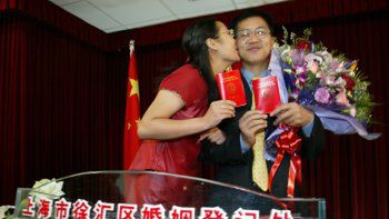 Szczęśliwi nowożeńcy z aktami ślubu