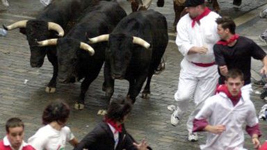 Setki ludzi biegło wraz z wypuszczonymi z zagrody bykami uliczkami Pampeluny