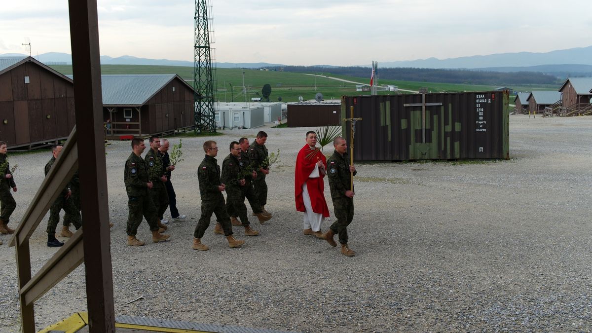 Kapelan wojskowy razem z żołnierzami na misji zagranicznej. 