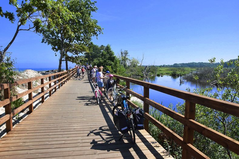 Kołobrzeg. Piesza i rowerowa kładka nad wydmami rozdzielającymi nadmorską plażę od torfowisk 