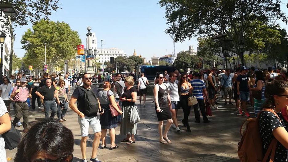 Ludzie zbierają się przy ulicy La Rambla, aby oddać hołd ofiarom zamachu 