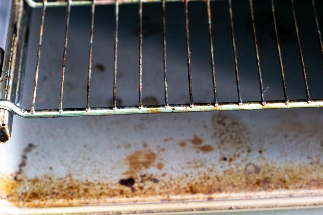 Dirty kitchen oven after cooking. The oven is greasy and stained.