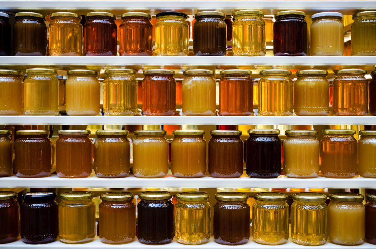 Jars of different honey varieties stocked on a shelf 