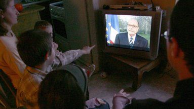 Francuska rodzina ogląda w telewizji wystąpienie prezydenta