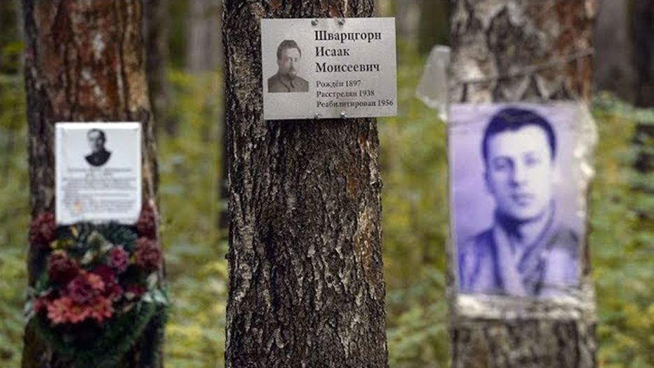 Na drzewach na terenie Kommunarki umieszczono fotografie i tabliczki z informacjami o ludziach, którzy tam spoczywają