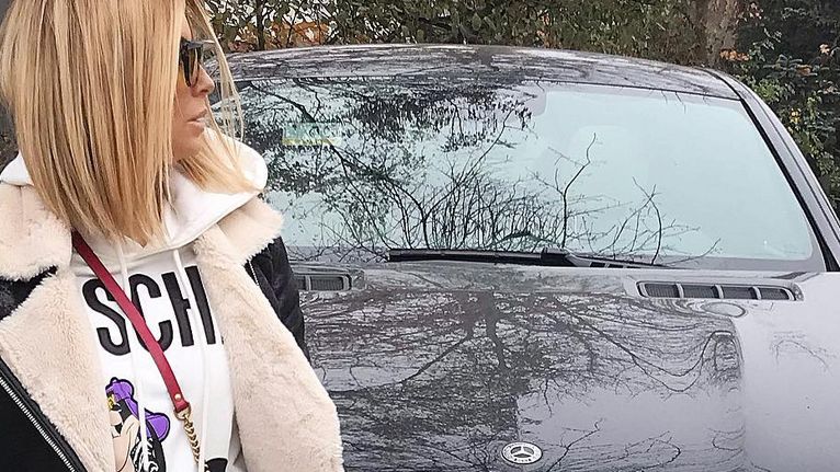 Małgorzata pozuje z samochodem.