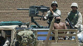 Amerykańscy żołnierze konwojują jednego z aresztowanych