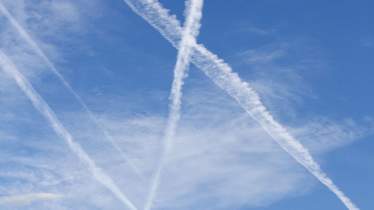 Blue sky with clouds and white airplane trace 