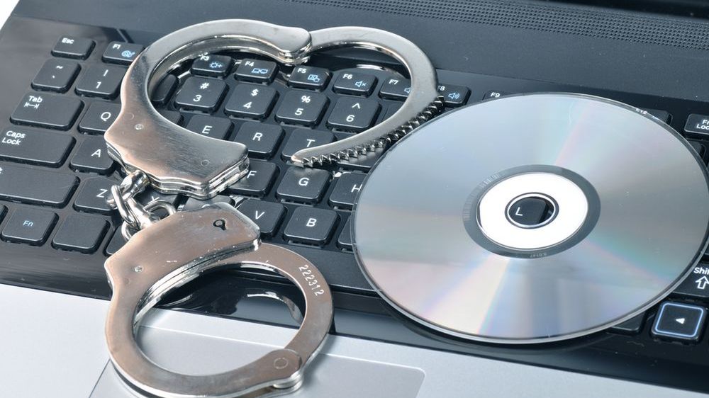 Handcuffs and CD - ROM on laptop