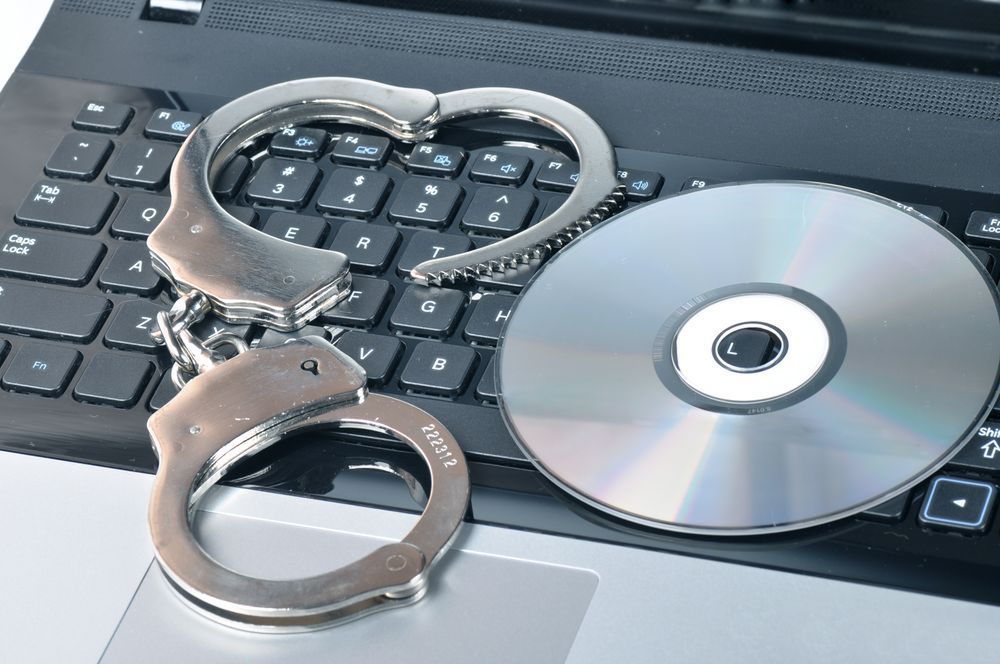 Handcuffs and CD - ROM on laptop