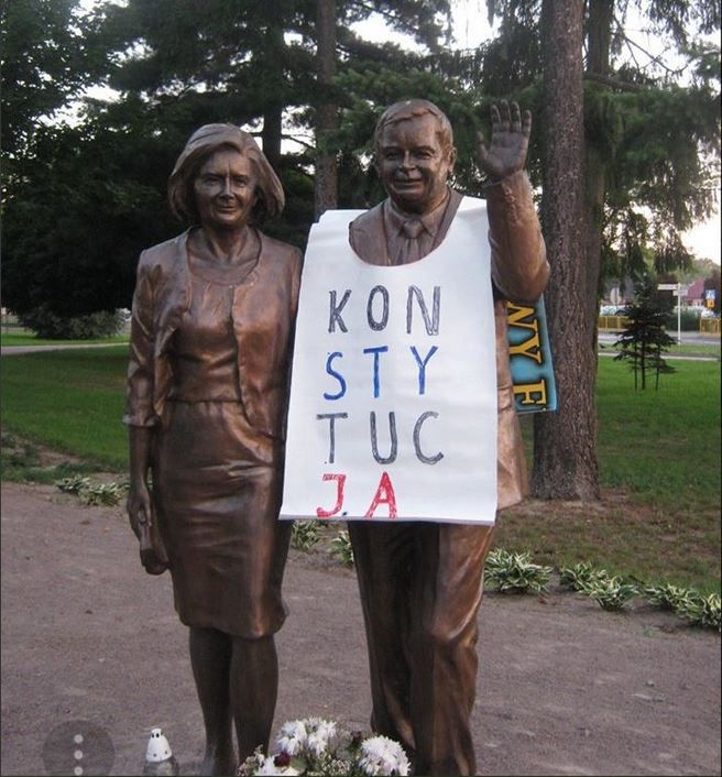 67-latek, który przyozdobił pomnik Lecha i Marii Kaczyńskich banerem z napisem "Konstytucja" usłyszał zarzut znieważenia pomnika.