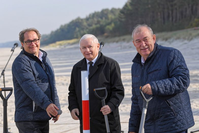 Jarosław Kaczyński, minister Marek Gróbarczyk (po lewej) i Jerzy Wilk (po prawej) podczas wbicia słupka w miejscu przekopu Mierzei Wiślanej.