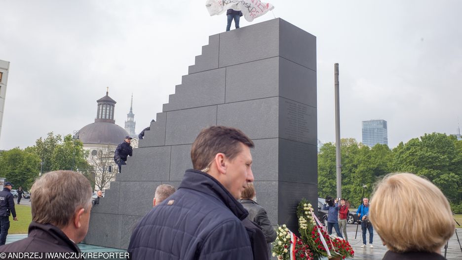 Arek Szczurek na szczycie pomnika rozwinął baner
