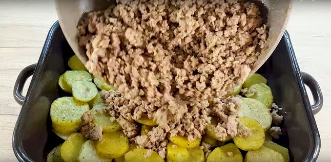 Przekładanie mięsa mielonego na ziemniaki - Pyszności; Foto kadr z materiału na kanale YouTube szybki przepis