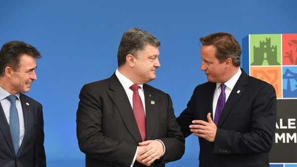 Prezydent Ukrainy Petro Poroszenko wita się z premierem W. Brytanii na szczycie NATO