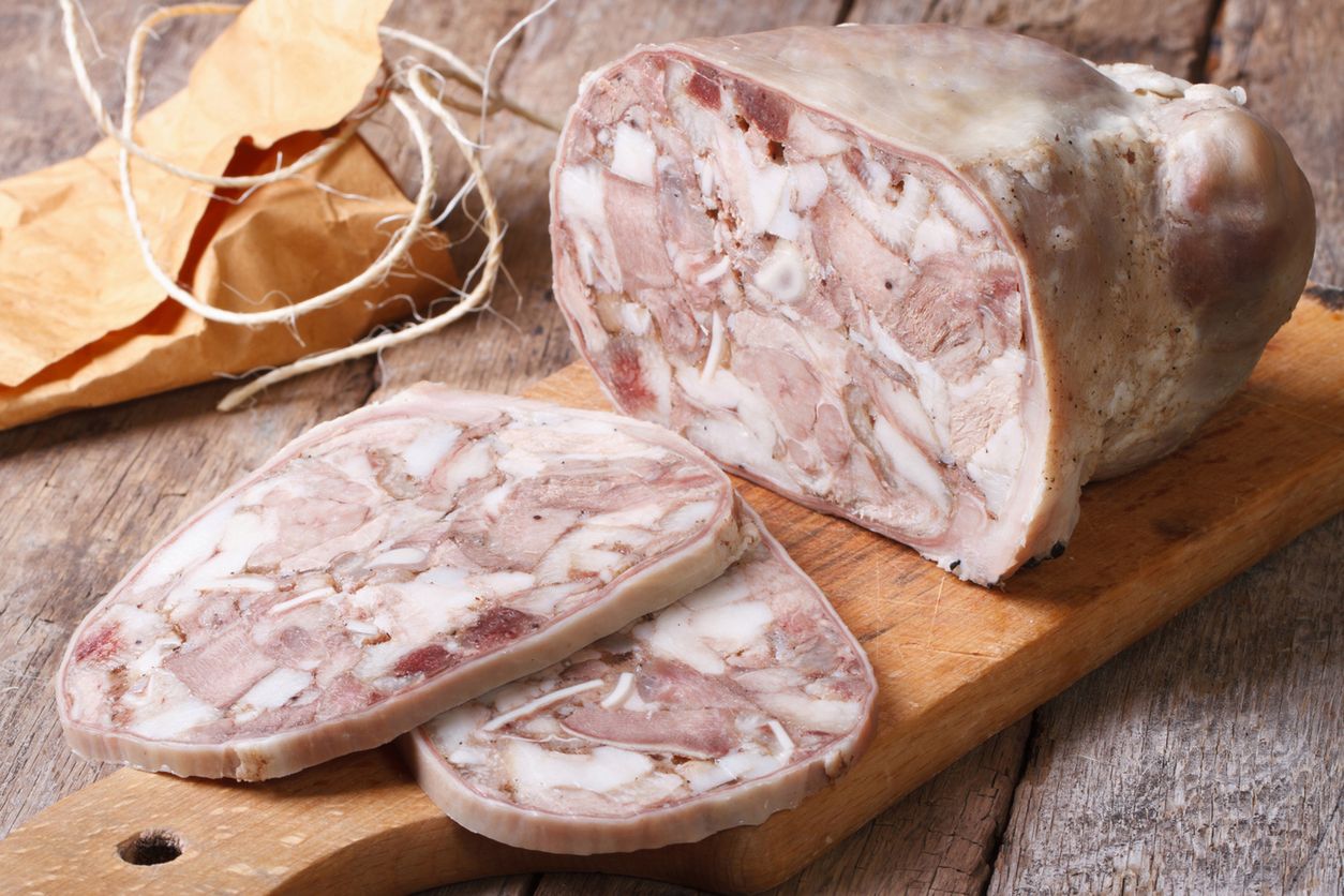 Cut headcheese on chopping board close-up. horizontal

