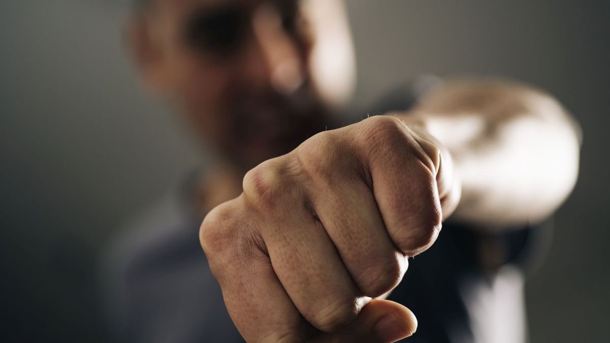 closeup of a young caucasian man throwing a punch to the observer, with a dramatic effect