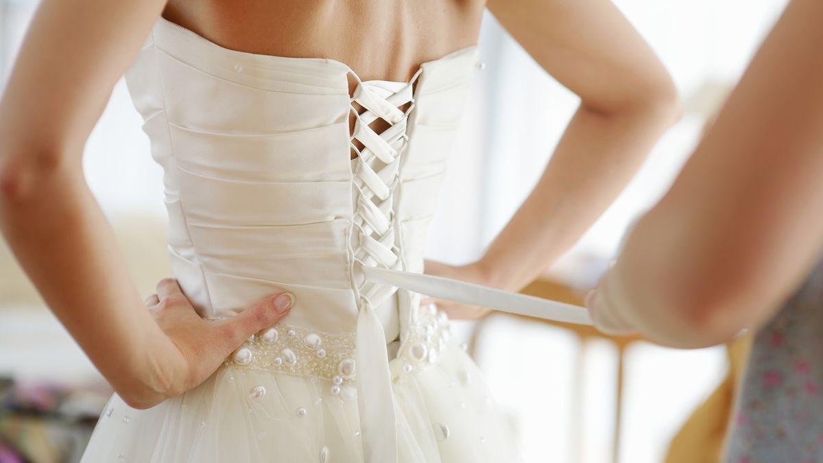 Helping the bride to put her wedding dress on
