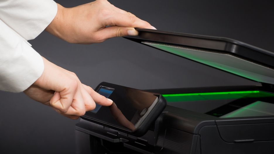 Woman using scanner multifunction device on black background.