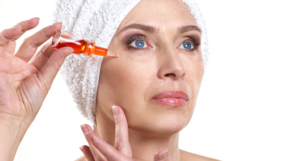 mature woman doing rejuvenation  spa procedure for face on white background