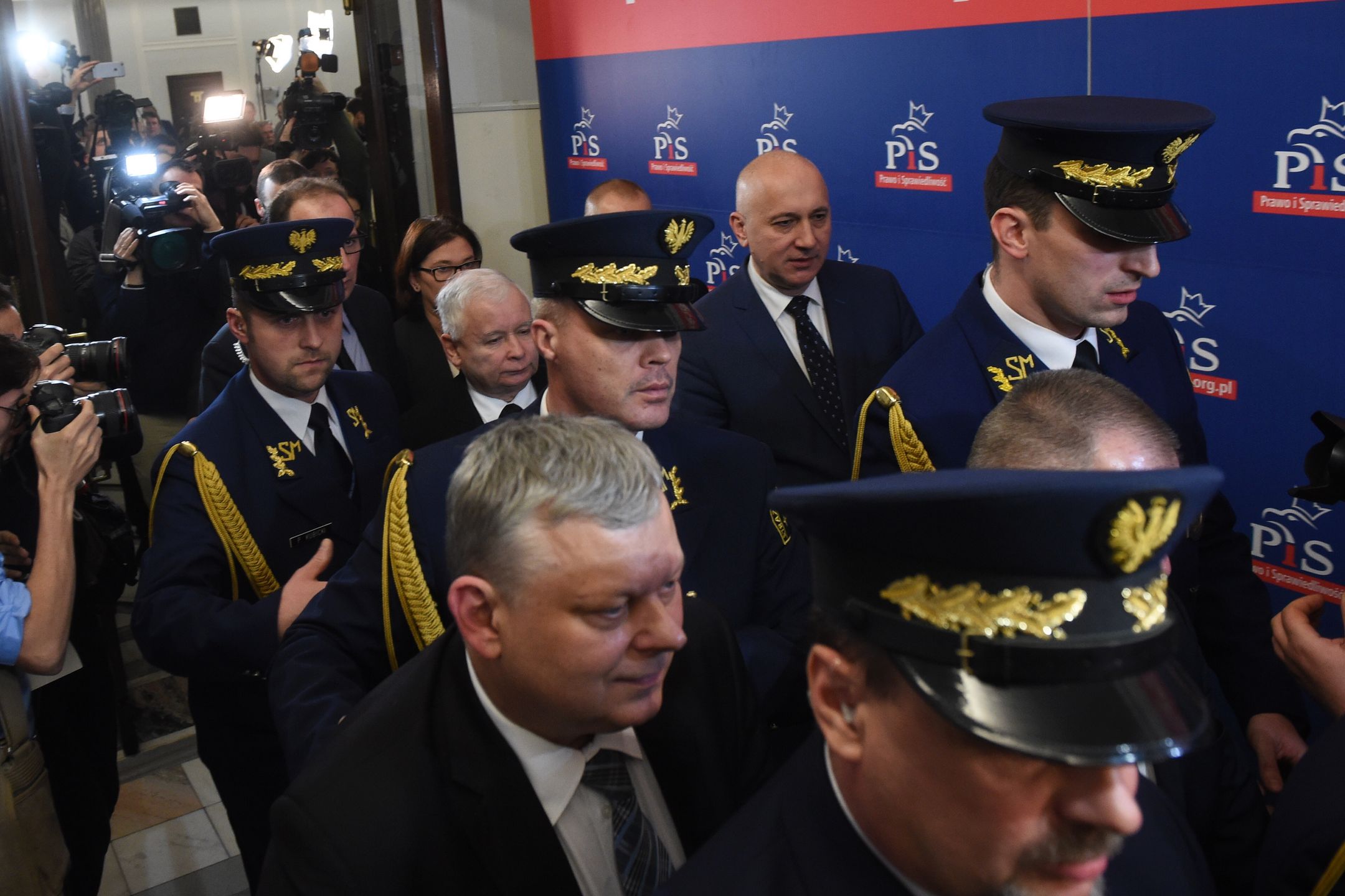 Czołowi politycy PiS w otoczeniu funkcjonariuszy Straży Marszałkowskiej