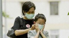 Matka pomaga synowi założyć maskę