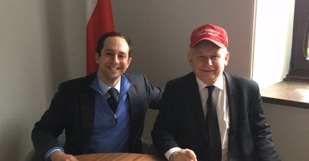 Uśmiechnięty Jarosław Kaczyński w czapeczce Donalda Trumpa