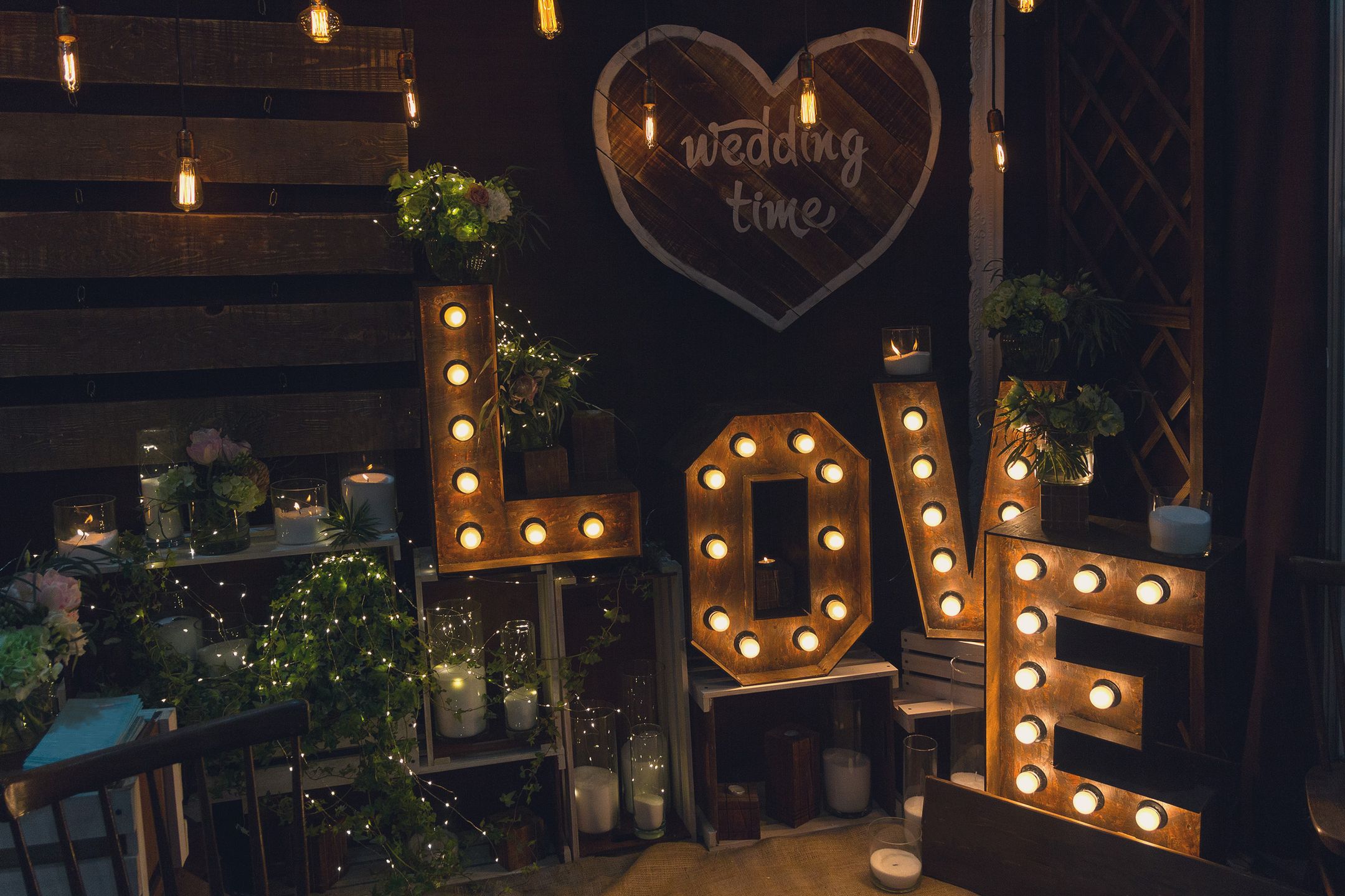 Sign of love with a light bulb and a candle on a dark background 