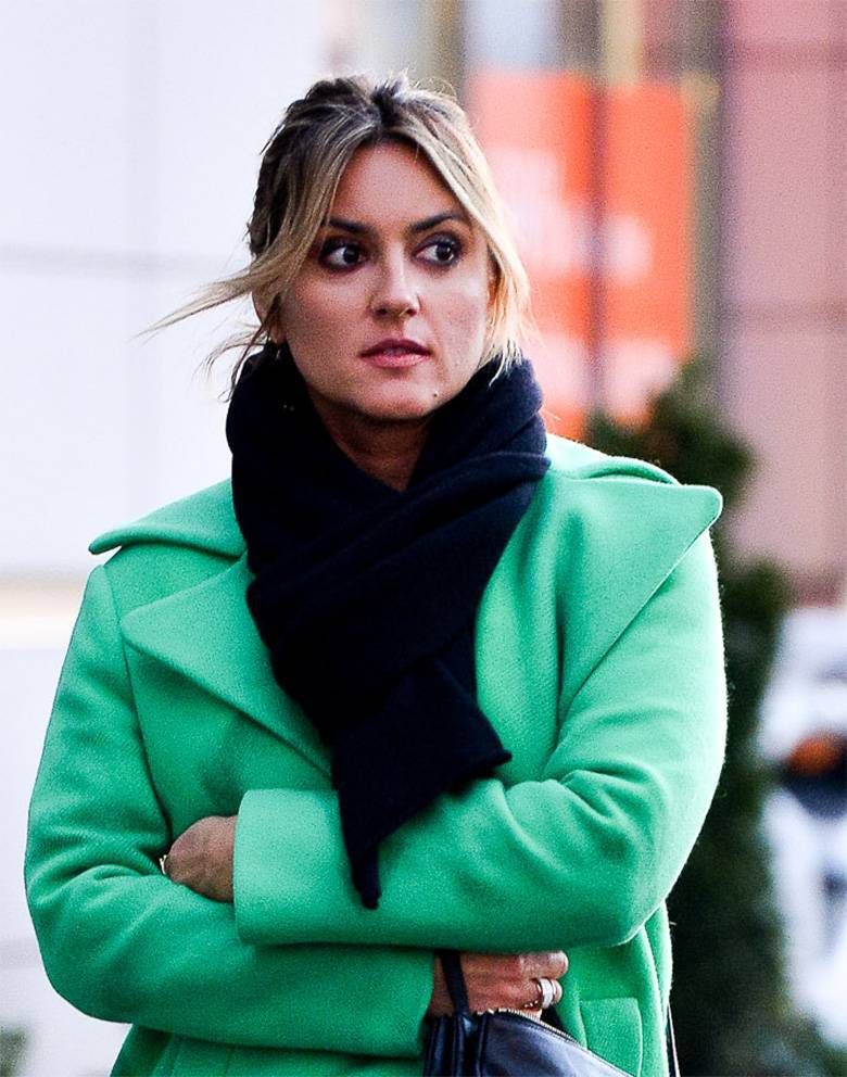 Karolina Szostak w zielonym płaszczyku w banku
