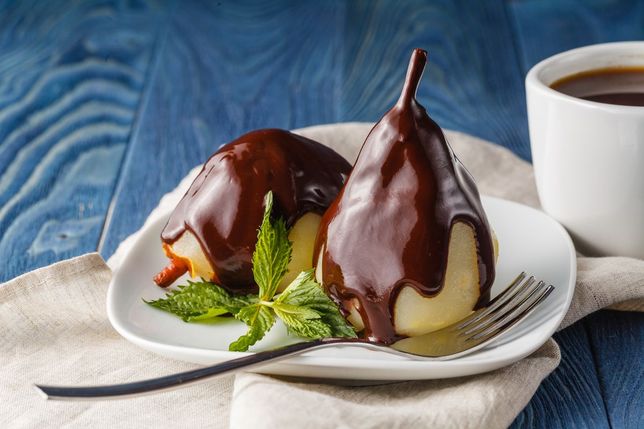 Pear on the plate with mint and chocolate sauce 