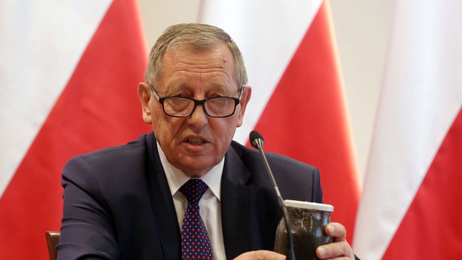 Jan Szyszko trzyma w rękach słoik z kornikami 