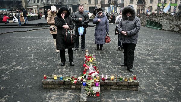 Ukraińcy modlą się przed, ułożonym z kamieni, krzyżem