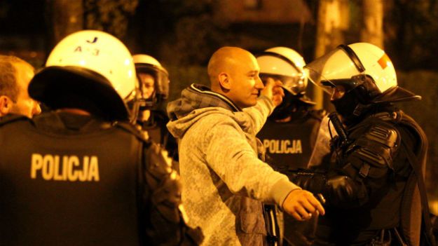 Policjanci przeszukują pseudokibiców, którzy próbowali wzniecić zamieszki przed komisariatem policji w Knurowie