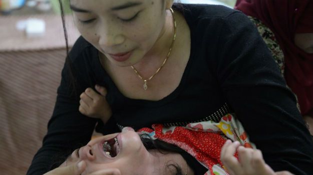 Indonezyjka próbuje uspokoić 4-letnią córkę, którą poddała zabiegowi obrzezania