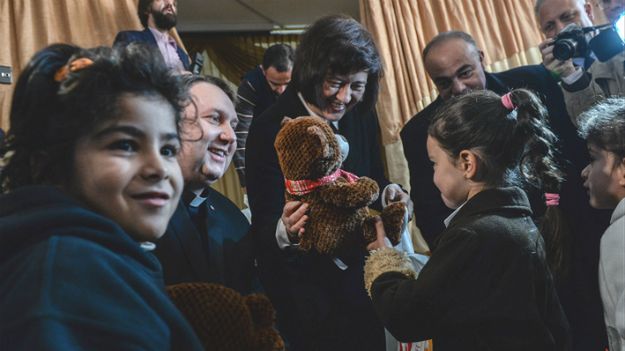 Minister Joanna Wronecka z księdzem Tomaszem Jegierskim wręczają prezenty dzieciom