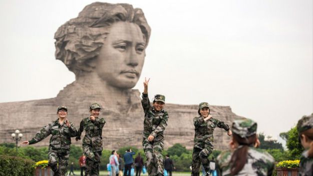 Chińskie żołnierki pozują przed 32-metrowym pomnikiem młodego Mao Zedonga w Changsha w prowincji Hunan