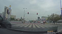Rowerzysta przejeżdża przez ruchliwe skrzyżowanie na czerwonym świetle 