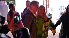 Margaret w kurtce robotnika i klapkach wytyka język w stronę paparazzi