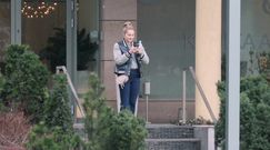 Małgorzata Socha wpatruje się w telefon pod kliniką medycyny estetycznej