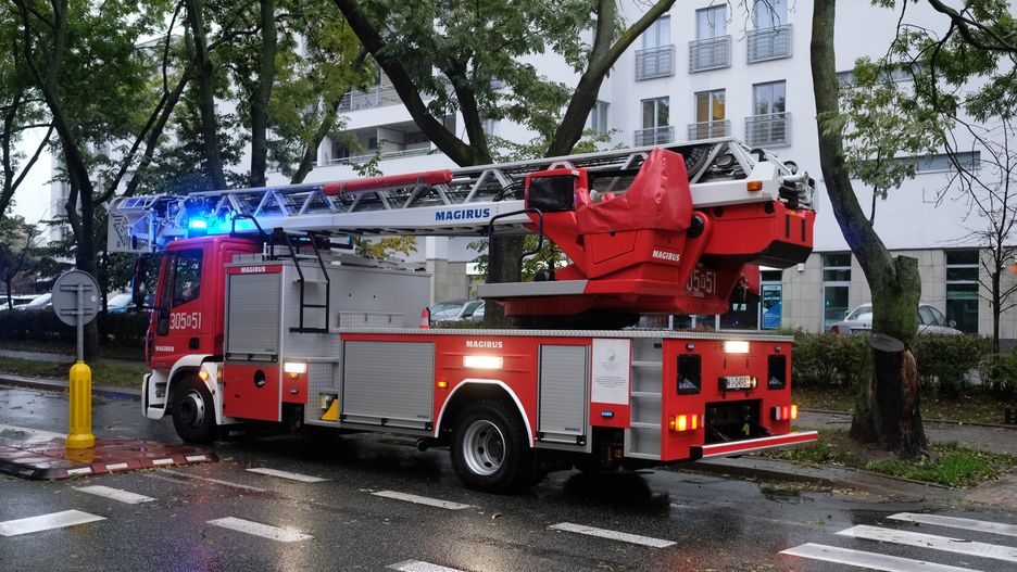 Warszawa. Strażacy pracują w alei Jana Pawła II. Z wieżowca Varso Tower spadają kawałki lodu.