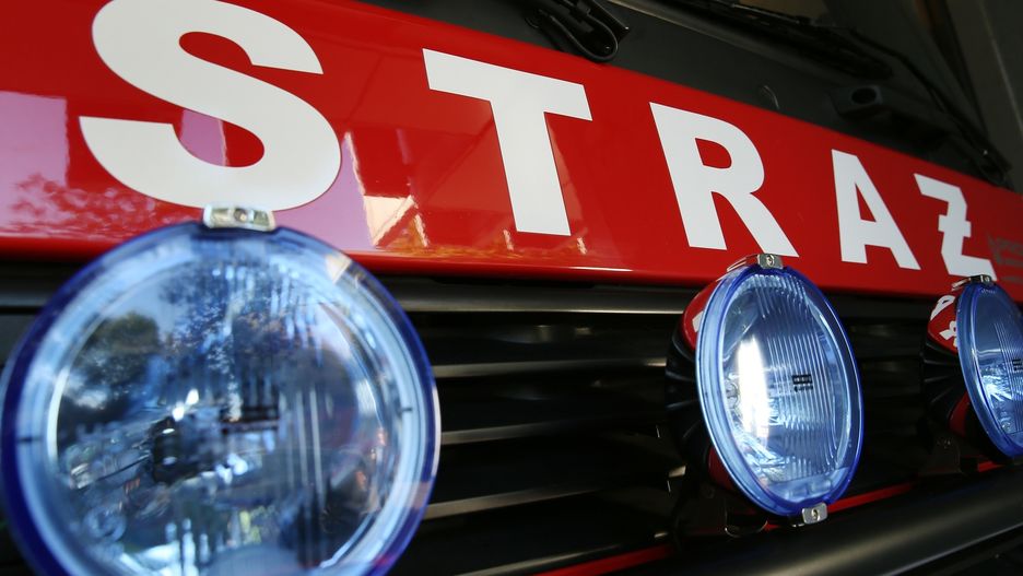 Straż pożarna usiłuje wydobyć operatora z przewróconej koparki