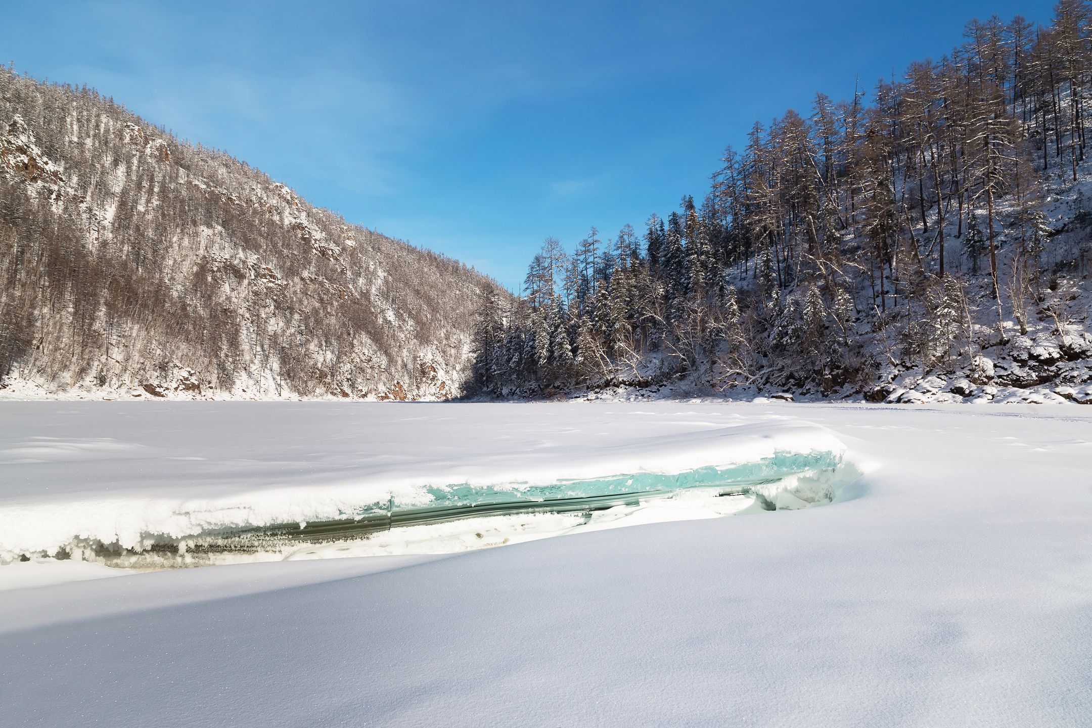 Winter landscape with frozen river and ice floe in the foreground, South Yakutia, Russia 