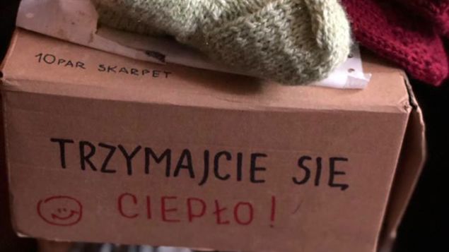 80-letnia kobieta trzyma wydziergane przez siebie skarpety dla niepełnosprawnych i ich opiekunów
